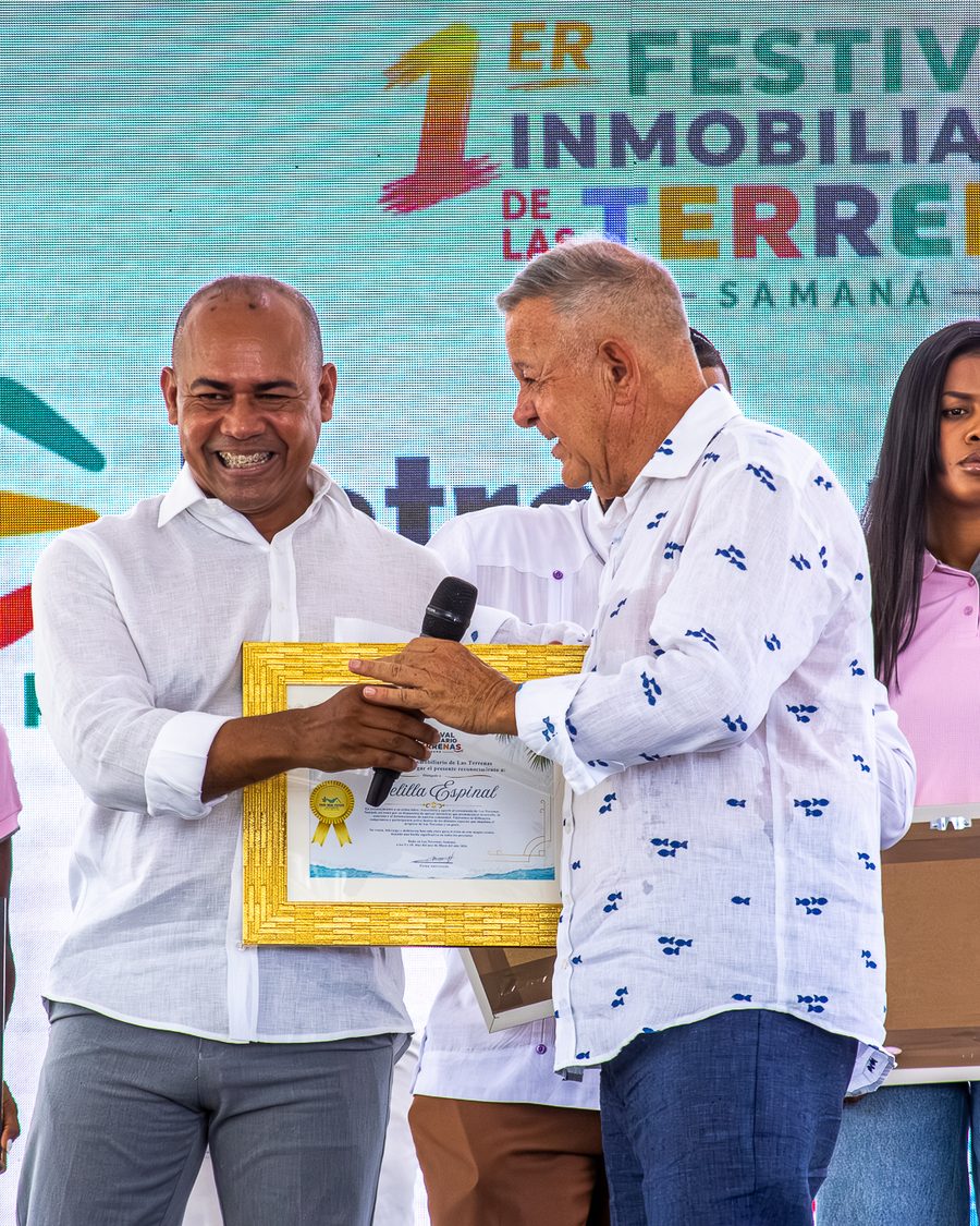 Dos participantes sostienen un diploma durante la premiación