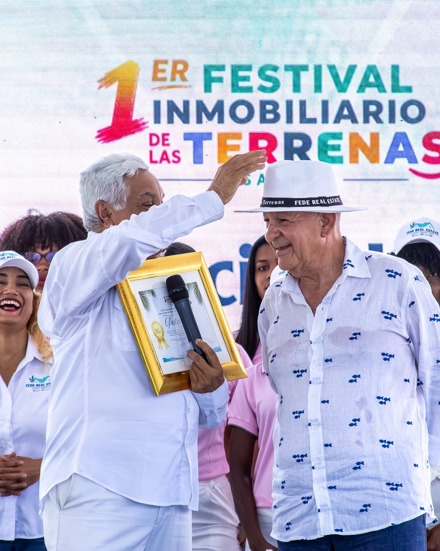 El organizador coloca el sombrero del festival a un premiado