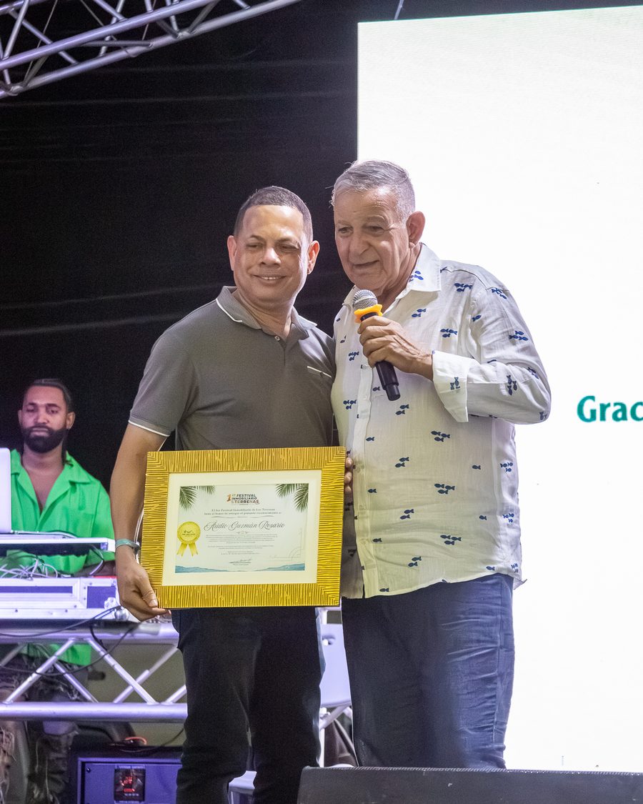 Entrega de un diploma enmarcado a un participante del festival